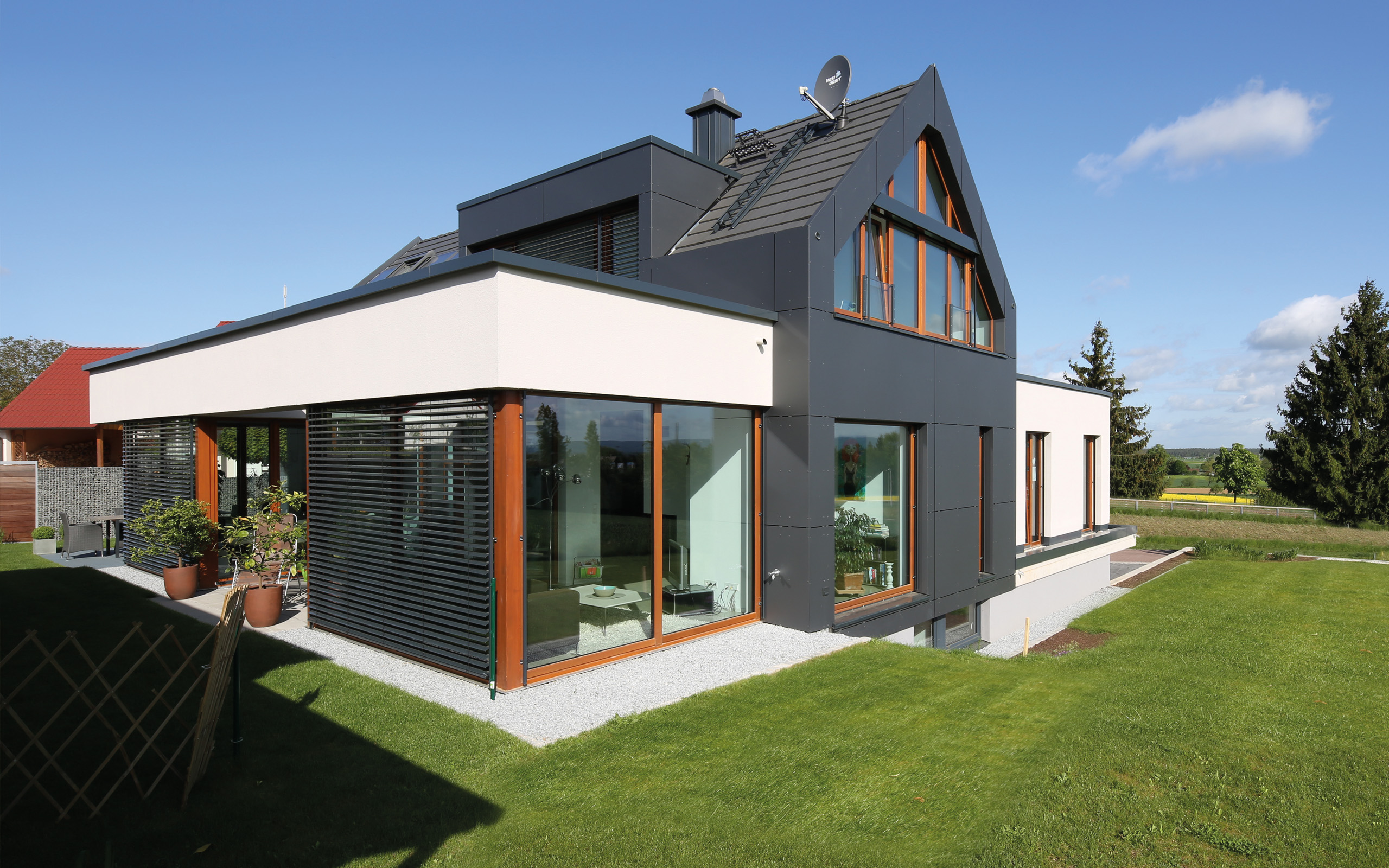 Aus- und Einblick – Gartenfassade mit umlaufender holzgerahmter Fensterfront