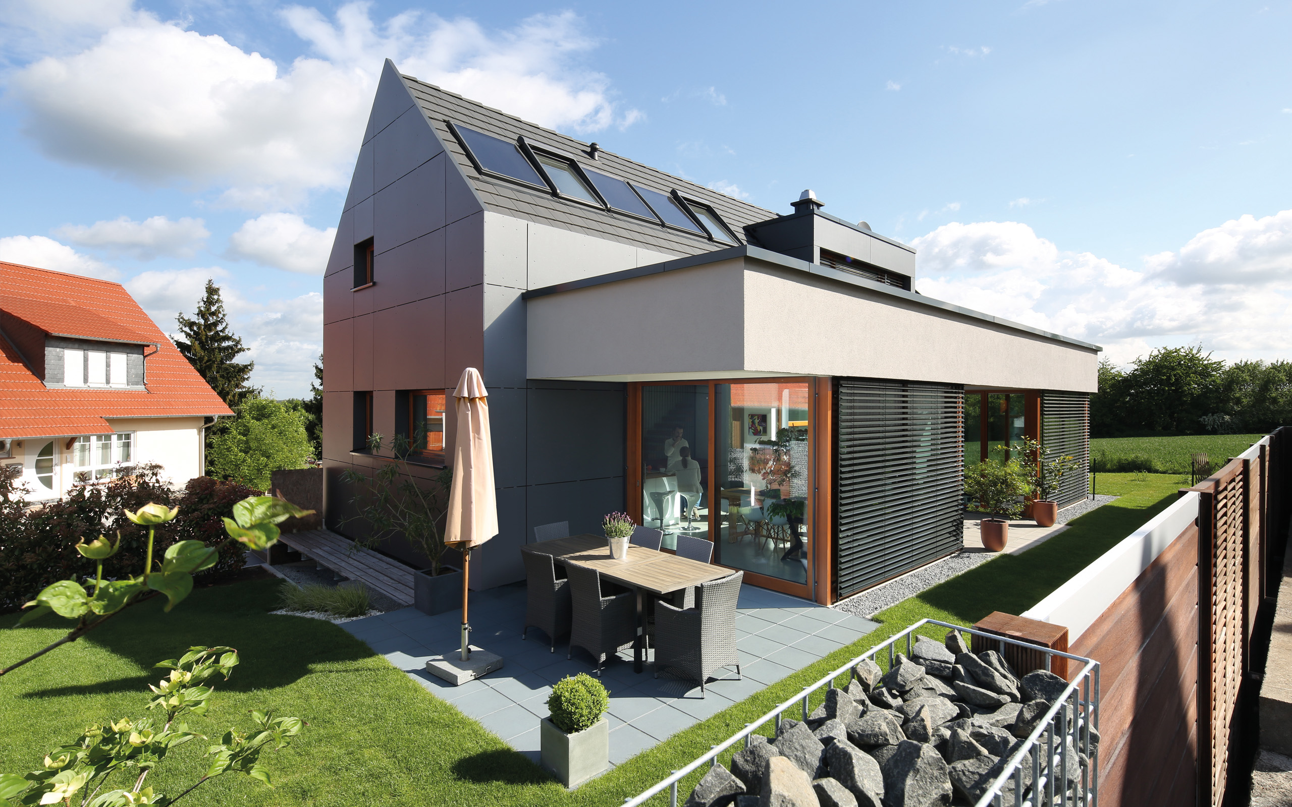 Aus- und Einblick – Terrasse mit Sonnenschirm und Gabionenwand