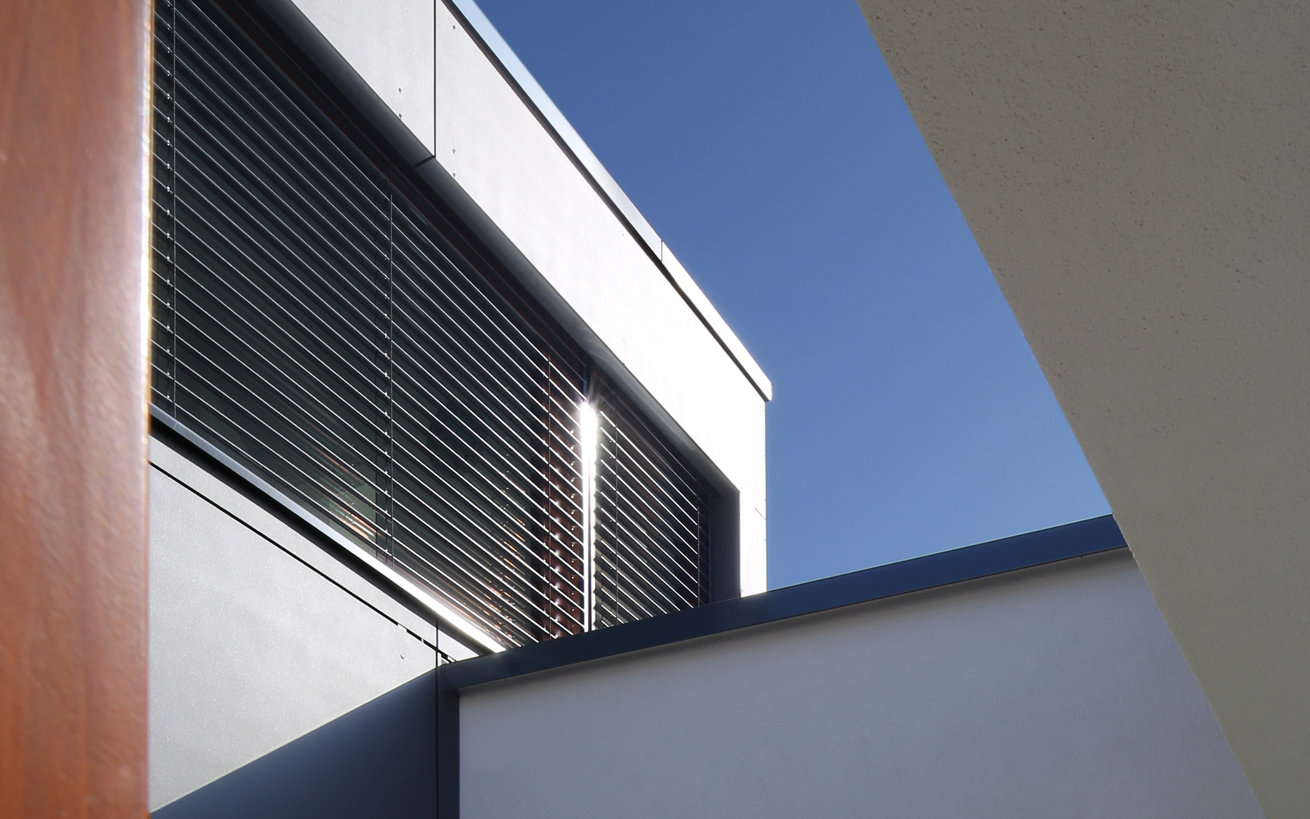 Aus- und Einblick – Fassadendetail mit dunklem Fensterband und Raffstore