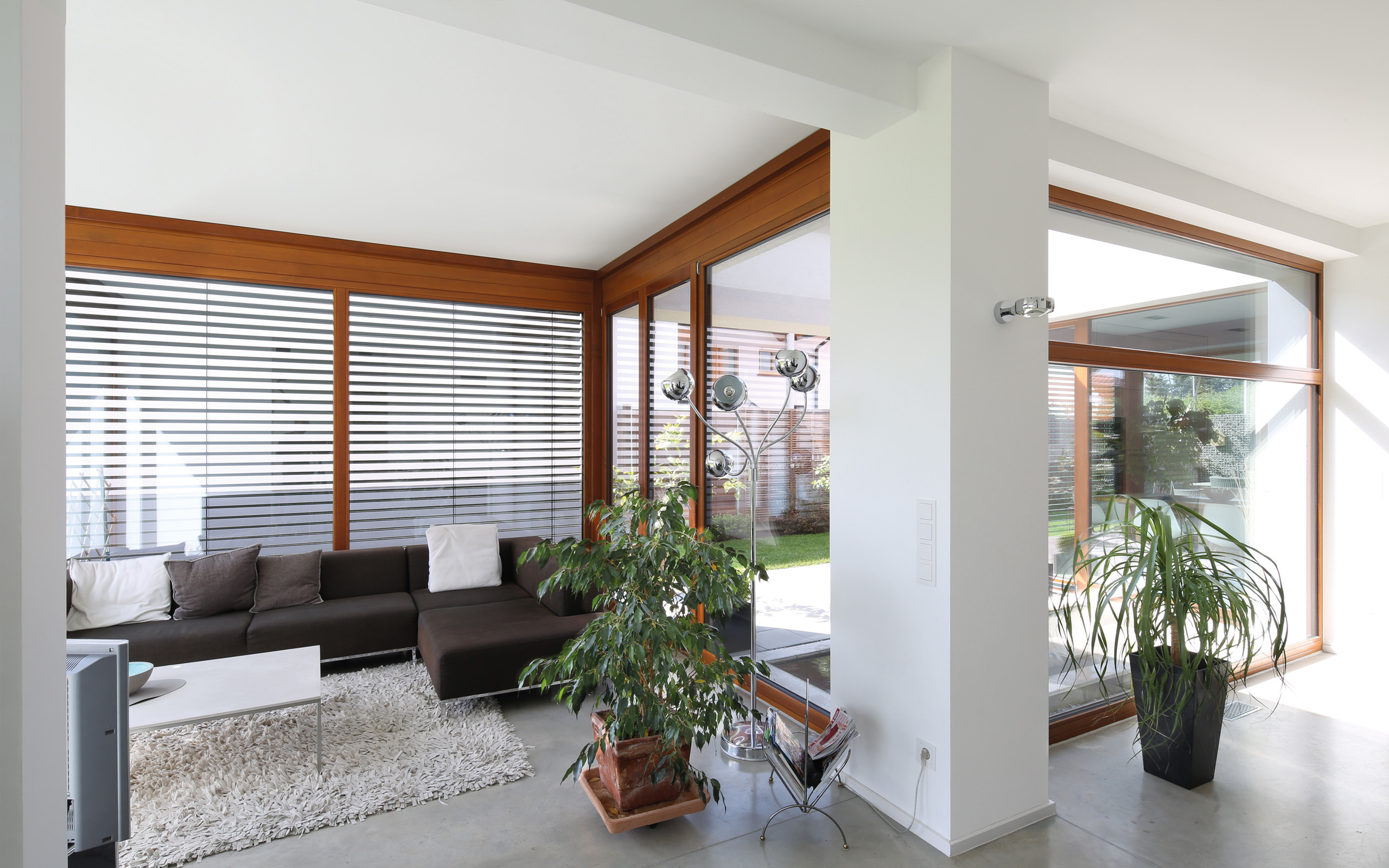 Aus- und Einblick – Wohnzimmer mit Sofalandschaft an der Eckverglasung