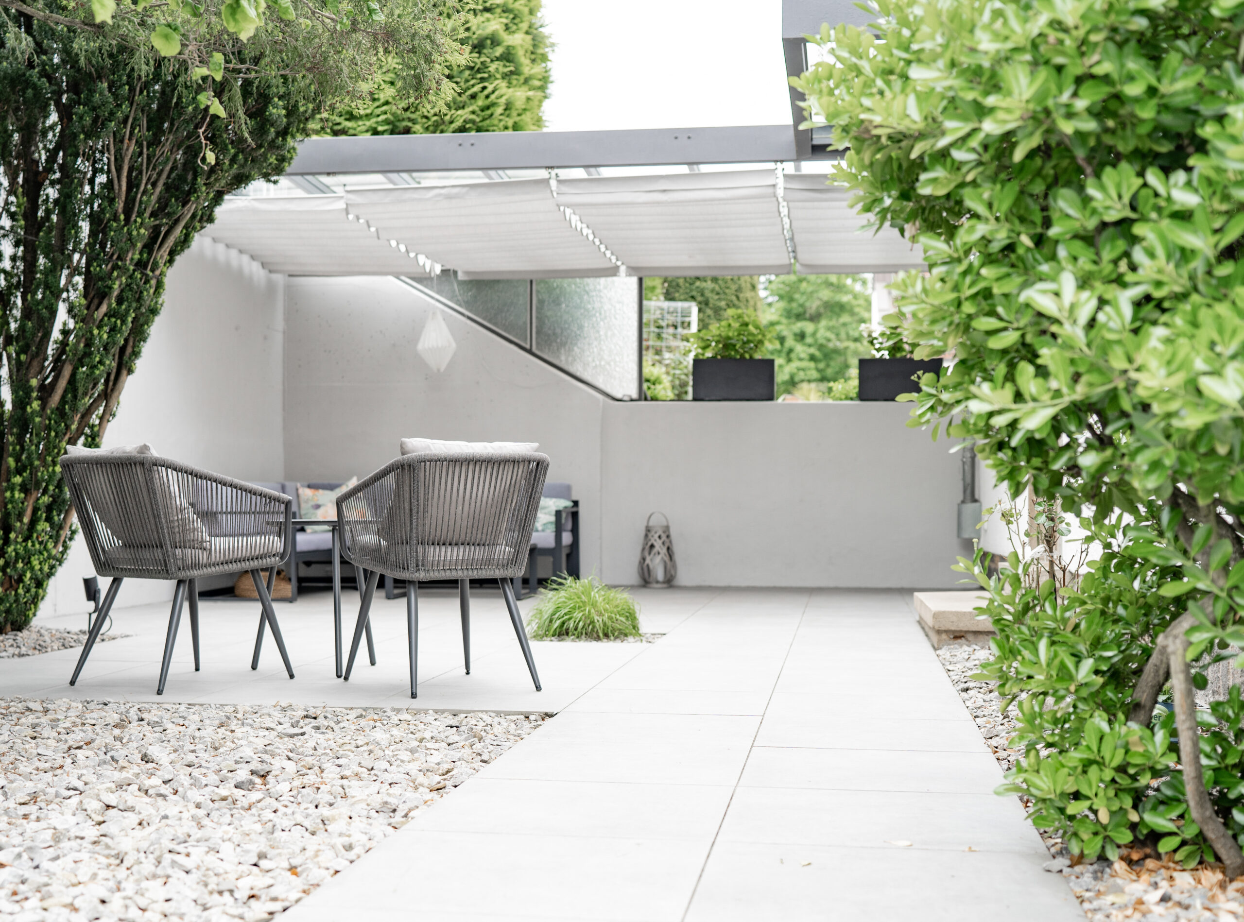 Haus BB – Gartenterrasse mit Kiesfläche und Outdoor-Sesseln