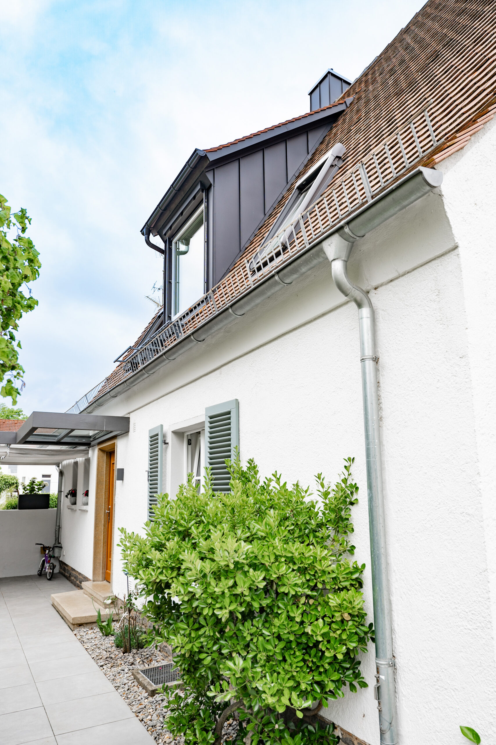 Haus BB – Seitenansicht mit Gaube und überdachtem Eingang