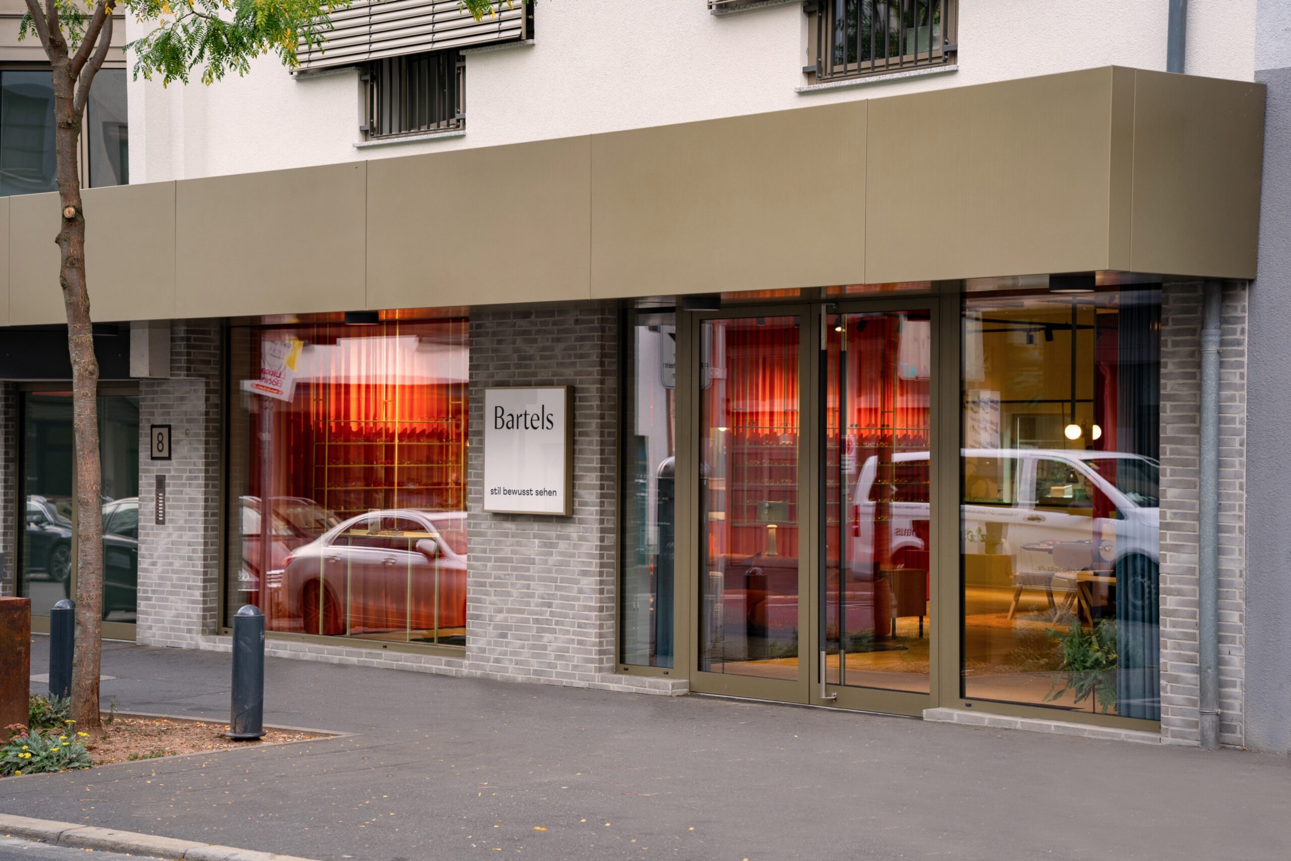 Geschäftshaus GH & BO – revitalisierte Erdgeschosszone mit Eingang und bronzefarbenem Vordach