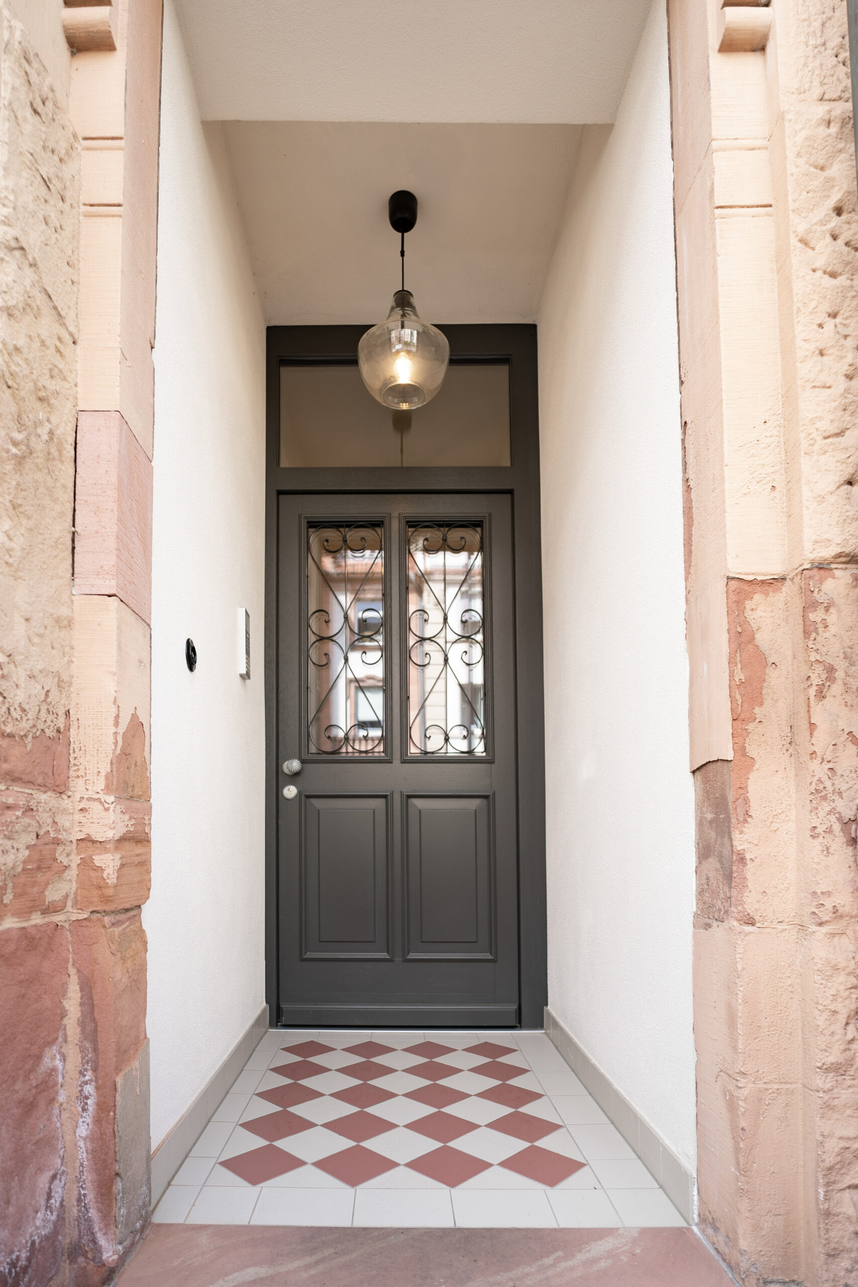Saniertes Gründerzeit-Treppenhaus – historische Haustür mit Oberlicht und Sandsteinportal