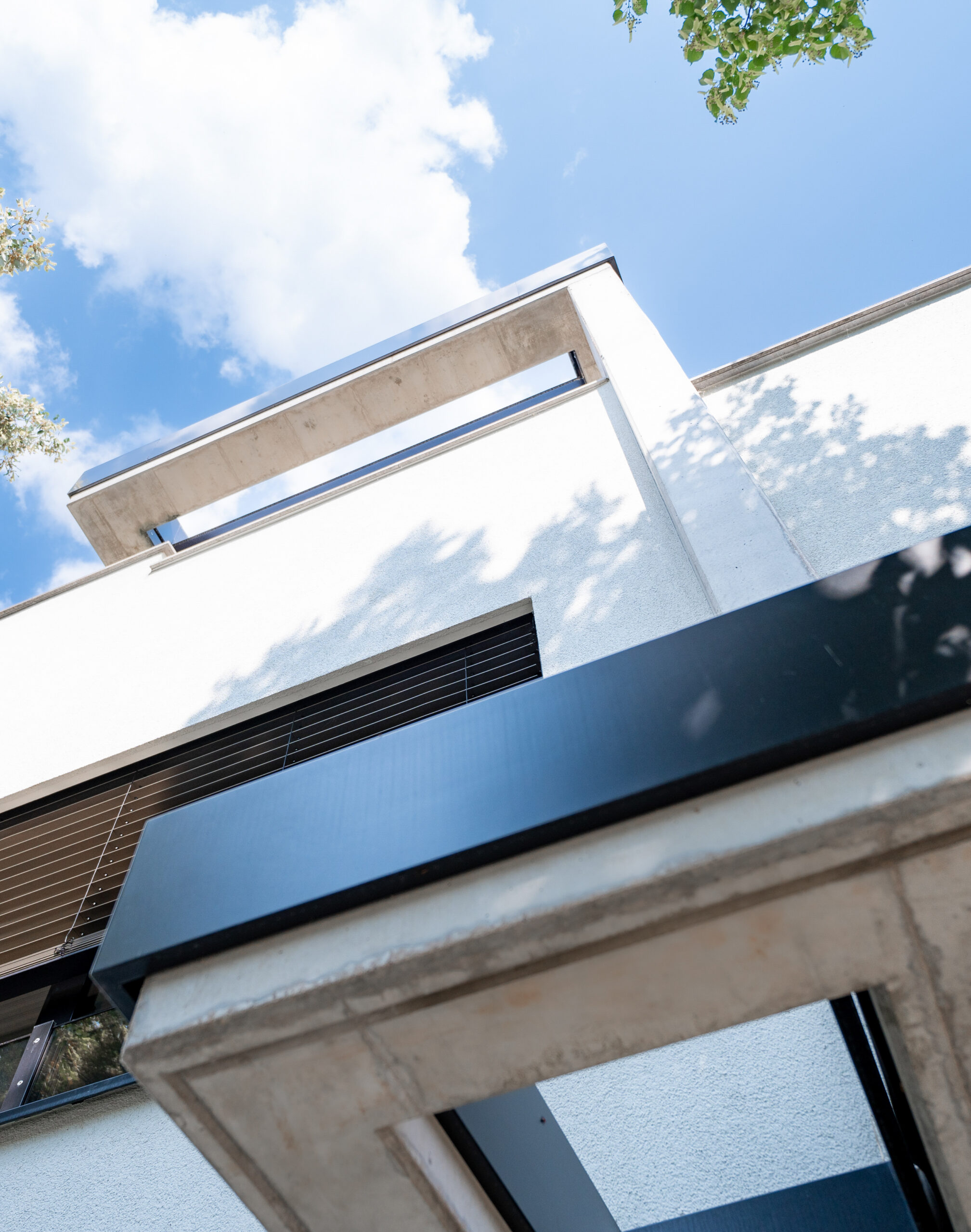 Haus WIE – Untersicht der auskragenden Baukörper vor blauem Himmel