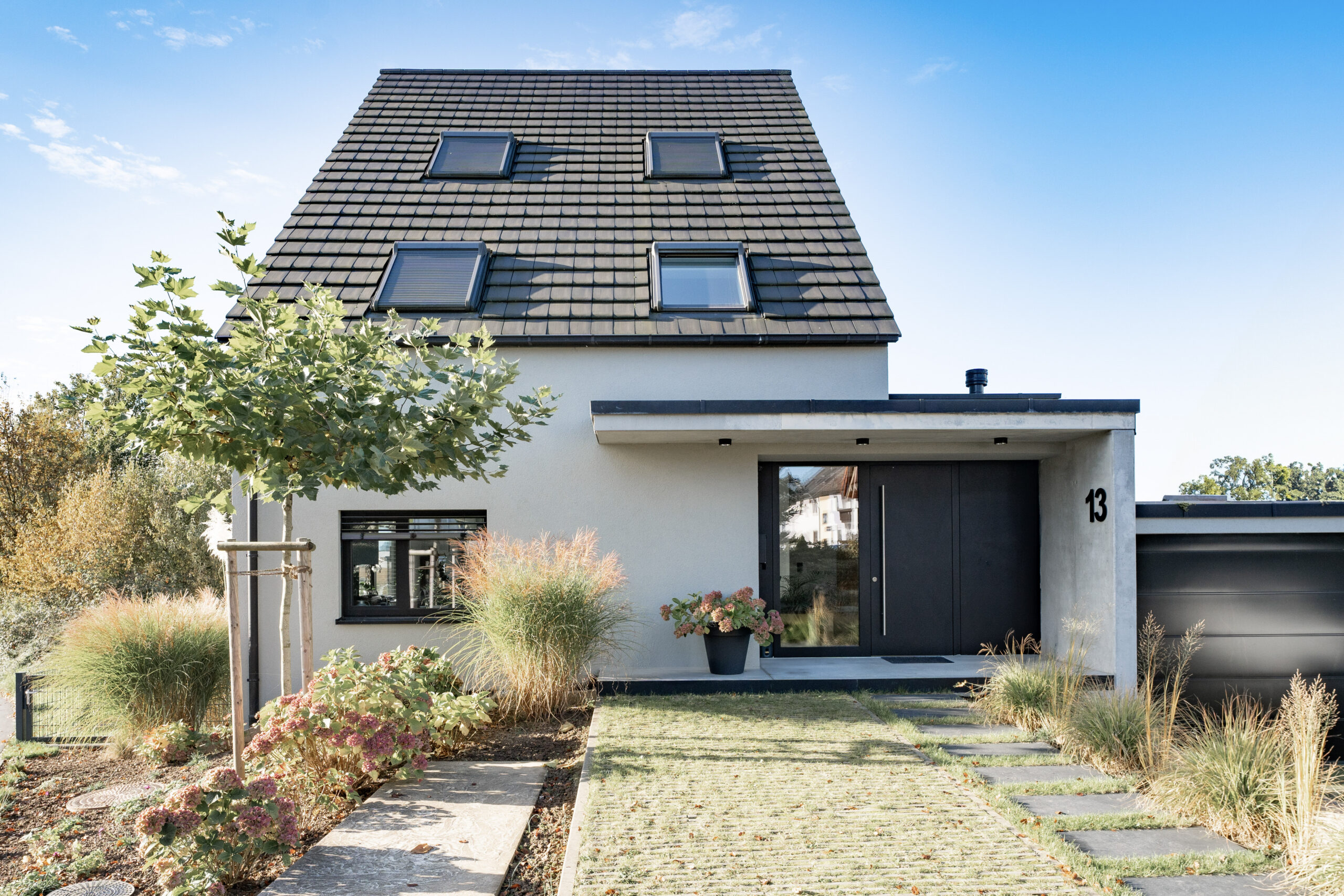 Haus LGW – Eingangsseite mit Kiesgarten und Trittplatten