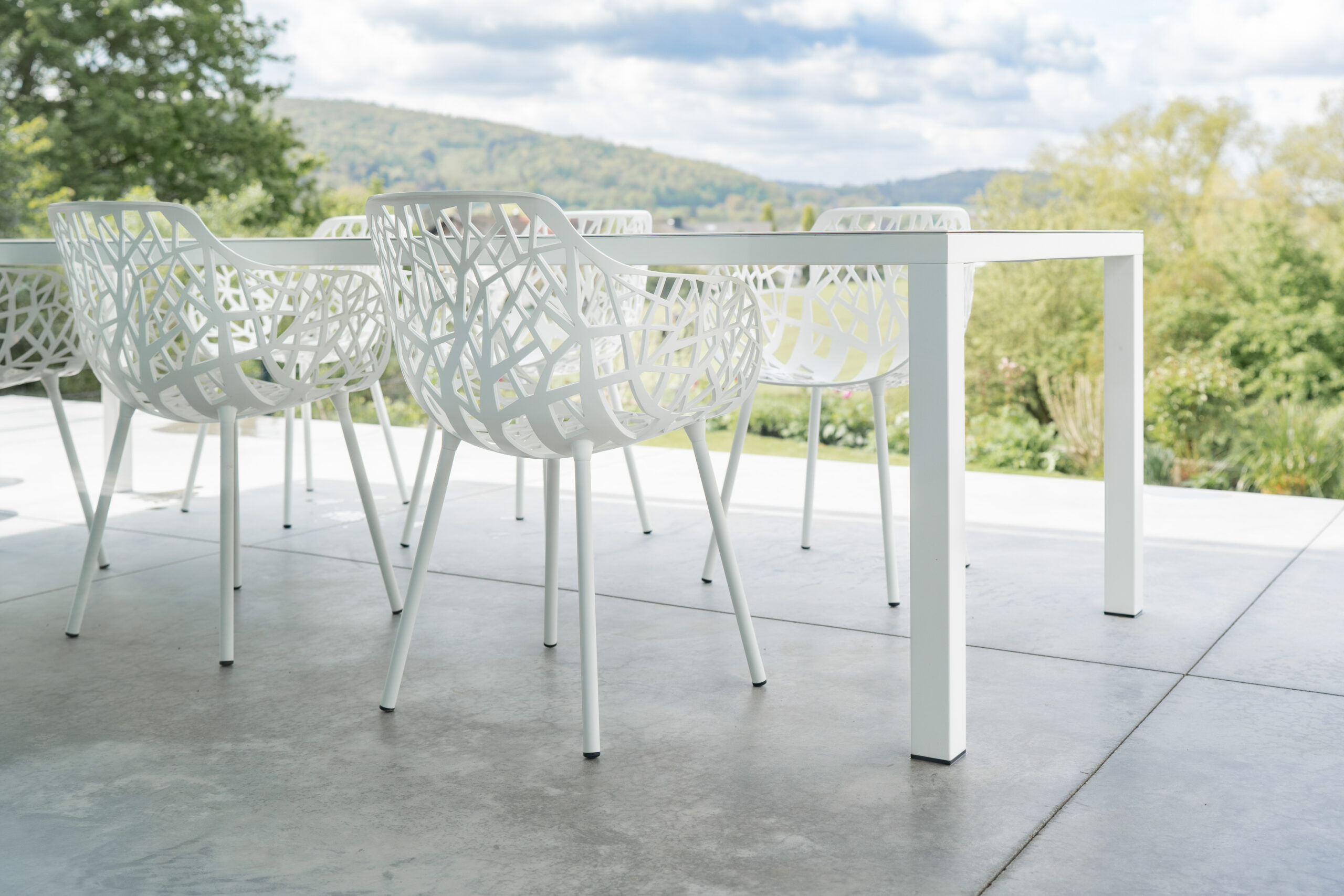 Haus LGW – weiße Designstühle auf der Betonterrasse mit Weitblick