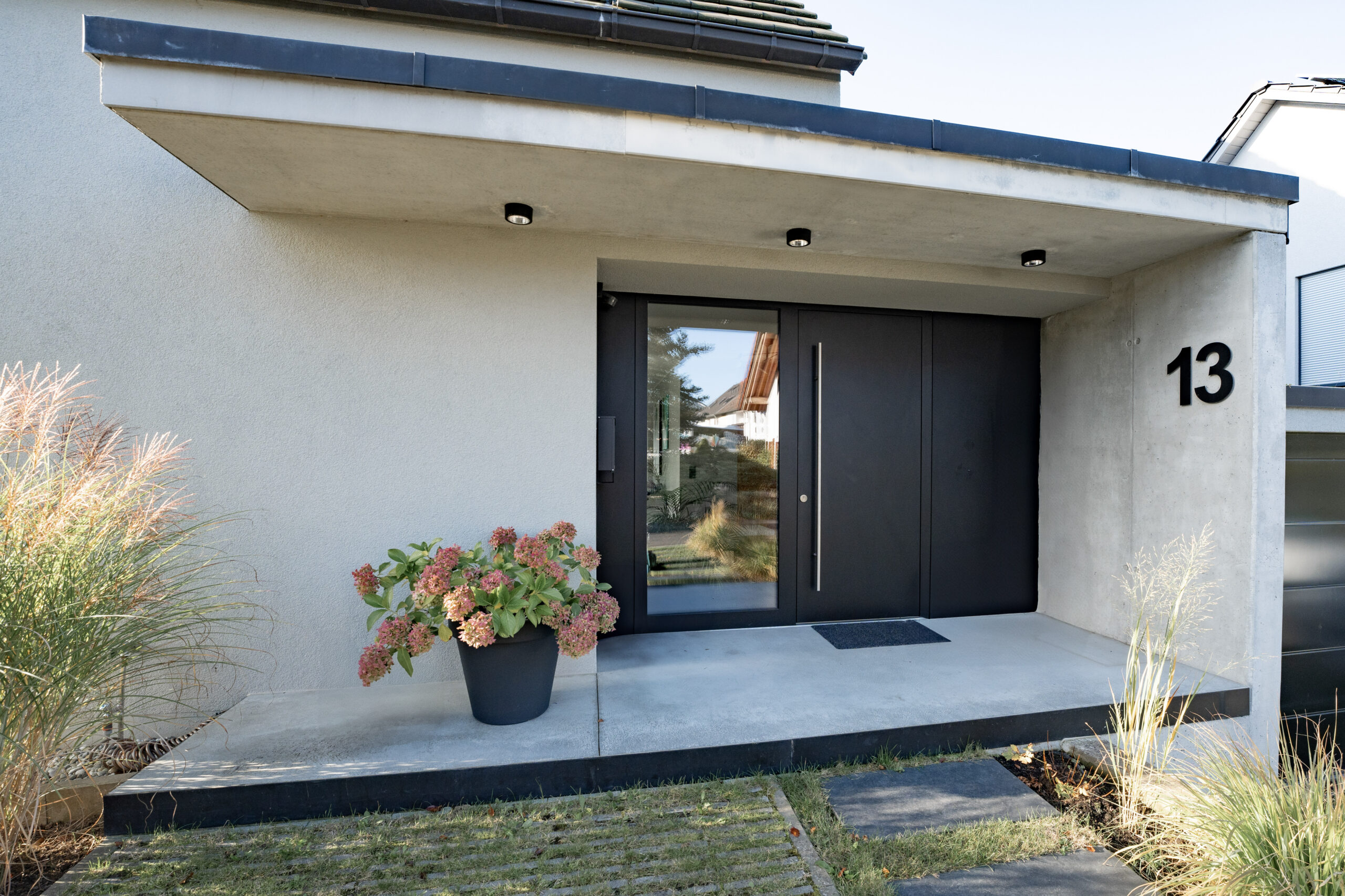 Haus LGW – überdachte Terrasse mit auskragendem Flachdach am Anbau