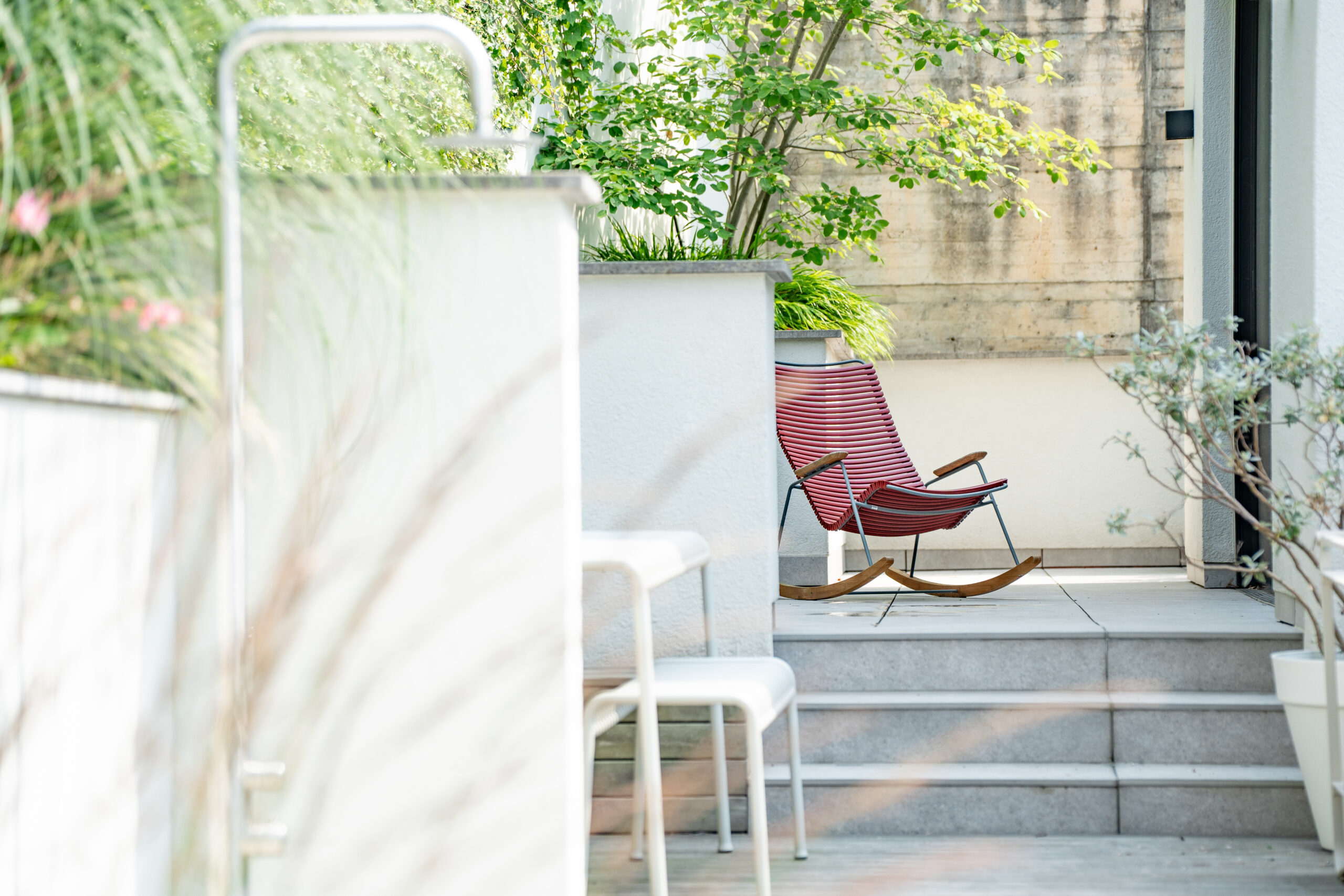Haus WIE – Terrasse mit Außendusche und Sitzplatz am Hang