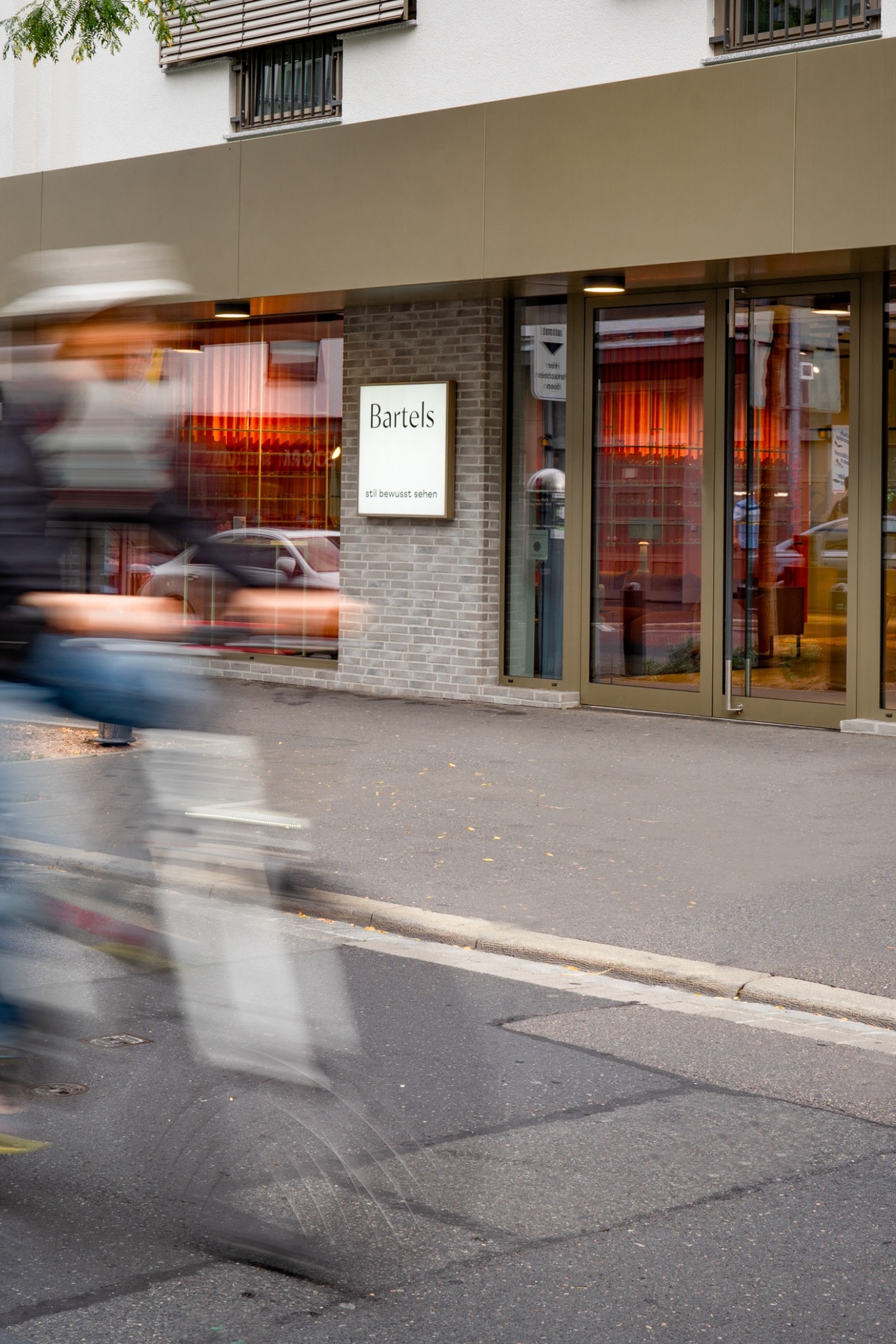 Geschäftshaus GH & BO – Straßenszene mit Radfahrer vor dem Ladeneingang